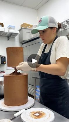 a woman decorating a chocolate cake in a kitchen