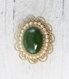 N6386Mid Century Asian 14K Yellow Gold Jade Pearl Pendant Brooch Filigree Pretty LuxuryNATURAL GREEN JADE CABOCHON WITH A ROW OF CULTURED PEARLS AROUND. FILIGREE DESIGN. AMAZING PENDANT / BROOCH PIN WONDERFUL HIGHEST QUALITY. VERY WELL MADE. JUST PART OF MY MOST RECENT ESTATE FINDS! FOLLOW ME TO SEE THEM ALL! Brand: AsianMetal Purity: 14kMetal: 14K Yellow GoldMaterial: Jade PearlForm: Pendant Brooch Filigree Pretty LuxurySize :1 1/4 x 1 3/8"Age: Mid CenturyWeight (Grams): 10.1IT IS IN EXCELLENT Elegant Green Gemstone Brooch, Elegant Green Gemstone Brooches, Elegant Green Oval Brooches, Green Round Brooch For Formal Occasions, Antique Green Brooch For Anniversary, Green Gemstone Brooch For Anniversary, Green Oval Brooches For Formal Occasions, Antique Green Brooches For Anniversary, Oval Green Brooch Jewelry