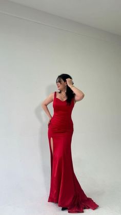 a woman in a red dress is posing for the camera with her hand on her head