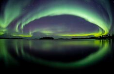 an aurora bore is reflected in the water