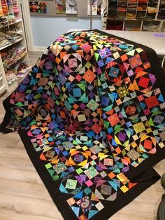 a colorful quilt is laying on the floor