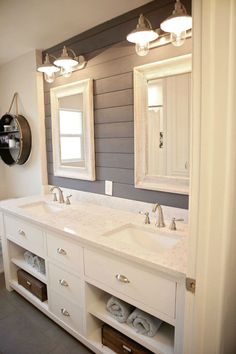 a bathroom with double sinks and two mirrors