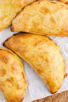 three pastries sitting on top of a piece of wax paper