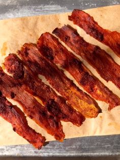 bacon strips sitting on top of a piece of parchment paper