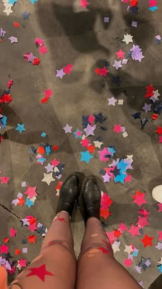 a person standing in front of colorful stars on the ground with their legs crossed out