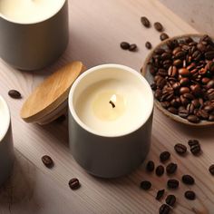 three candles are sitting on a table with coffee beans