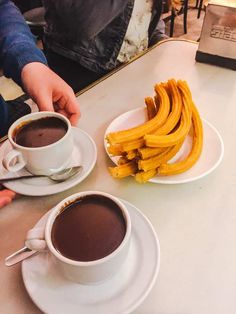 two cups of coffee and some bananas on a table