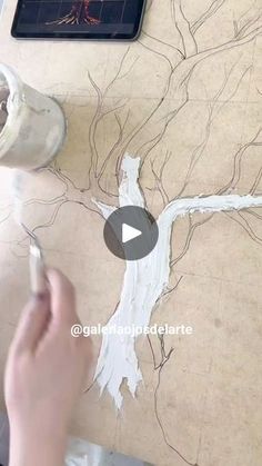 someone is painting a tree with white paint