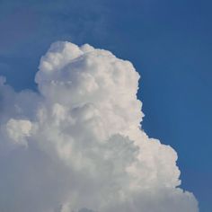 the plane is flying high in the blue sky with clouds behind it and an airplane on the ground below