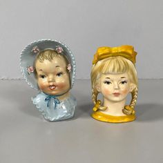 two porcelain figurines, one with blonde hair and the other with blue eyes