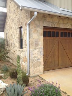 a stone house with two wooden garage doors