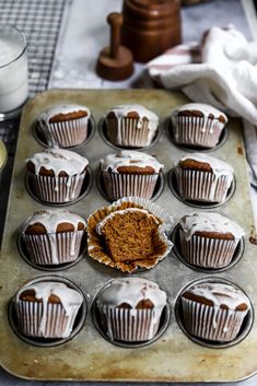 a muffin tin filled with chocolate cupcakes covered in frosting and cinnamon