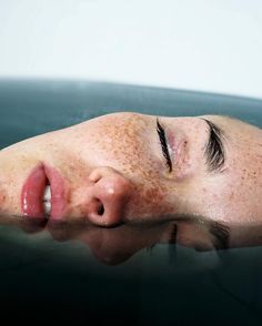 a woman's face is submerged in the water