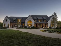 a large house with lots of windows in the front and side of it at night