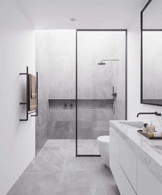 a modern bathroom with marble counter tops and white walls, along with a walk - in shower