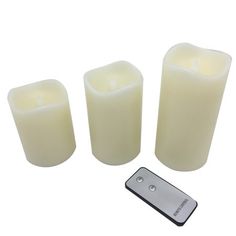 three white candles and a remote control