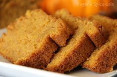 several pieces of bread sitting on top of a white plate next to some oranges