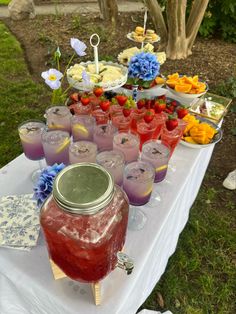 a table topped with lots of jars filled with liquid and flowers on top of it