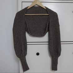 a gray sweater hanging on a white cabinet