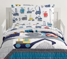 a child's bed with construction themed comforter and pillow shampoos on it