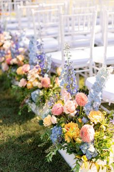 rows of chairs lined up with flowers and greenery on the aisles in front of them