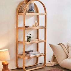 a bamboo shelf with books and magazines on it in the corner of a living room