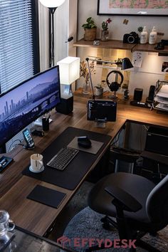 a desk with a computer monitor, keyboard and mouse on it in front of a window