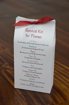 a survival kit for flamemen on a wooden table with a red ribbon tied around it