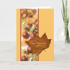 an autumn card with a maple leaf and acorns on the front, which reads happy thanksgiving