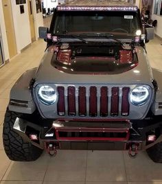 a jeep is parked in a building with lights on it's front bumpers