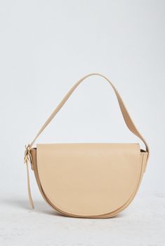 Featuring a crescent silhouette, this sleek shoulder bag adds a subtle nod of poise and personality to any outfit. The iconic half-moon shape allows room to store your keys, phone, wallet, and other small items secure with the interior zip pocket and magnetic closure. Complete with gold hardware and an easily adjustable shoulder strap for your comfort, this bag effortlessly takes you from day to night in style. 100% genuine leather 6.3”H x 10”W x 3”D Adjustable strap Shortest length: 7’’ Longest Moon Shape, Cream Lotion, Phone Wallet, Leather Care, Small Leather Goods, Toys Gift, Half Moon, Clutch Handbag, Small Items