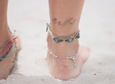 a woman's foot with a tattoo on it and a bracelet around her ankles