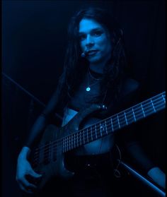 a woman with dreadlocks playing an electric guitar