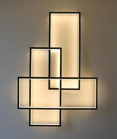 a modern light fixture hanging from the ceiling in a room with white walls and flooring