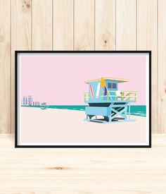 a framed print of a lifeguard's hut on the beach in front of a wooden wall