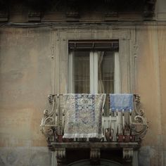 an old building with a window and some cloths hanging out to dry on the windowsill