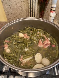 a pot filled with green beans and ham