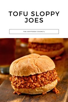 a sloppy joe sandwich sitting on top of a wooden cutting board