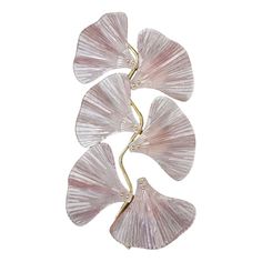 three pink flower shaped glass pieces on a gold plated stand