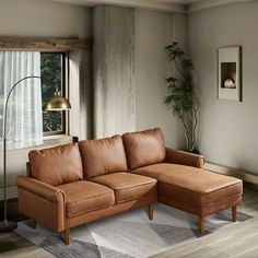 a living room with a couch, chair and lamp next to a large window in the corner