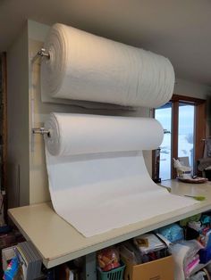 two rolls of white paper on top of a shelf in a room with other items