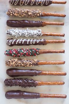 chocolate covered pretzels are lined up on a white counter top with sprinkles