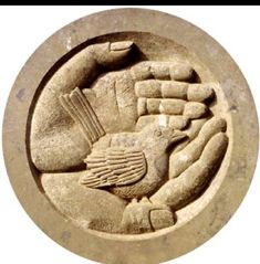 an image of a stone carving with hands and feet holding a bird on it's back