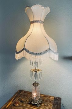 a lamp that is sitting on top of a wooden table next to a blue wall