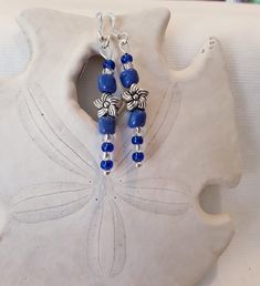 Blue and silver beaded earrings, with Silver Flower.  Blue beaded and Silver necklace and earrings.  Earrings are adorned with blue and clear glass beads with silver bead and flower accents.  A beautiful sparkle to added to your outfit.  These earrings represent the joy of spring and all the beauty brought by the colors of flowers.   The color blue represents both the sky and the sea and is associated with open spaces, freedom, intuition, imagination, inspiration, and sensitivity.  Perfect for evening, day or office wear.  Silver flower earring. Beaded earrings. Blue Earrings. Silver Earrings. Flower Earrings. Spring Earrings. **Necklace sold in separate listing. Purchase earrings for yourself or as a gift.  Think Mother's Day, Birthdays, Christmas, Valentine's Day, Anniversaries, Teacher Nickel-free Blue Flower Earrings, Blue Czech Glass Flower Earrings, Blue Flower-shaped Sterling Silver Earrings, Blue Flower Sterling Silver Earrings, Blue Sterling Silver Flower Earrings, Handmade Blue Sterling Silver Flower Earrings, Blue Silver Beaded Drop Earrings, Blue Flower-shaped Earrings With Ear Wire, Blue Flower Earrings Nickel Free