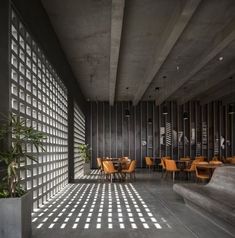 an empty room with tables and chairs on the floor, in front of a wooden wall