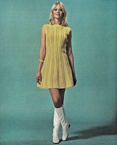 a woman in a yellow dress and white boots