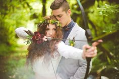 a man and woman are holding arrows in their hands while they look at each other