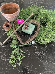 an arrangement of plants and gardening tools on a table with a tag that says love