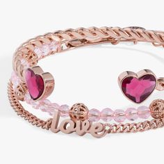 Love is all you need. Wear a daily reminder of the ones you love with this expertly styled set of 3 bracelets featuring a rose gold curb chain bracelet with “Love” written out in the middle, a twisted flex cuff with fuschia pink faceted crystal hearts, and a light pink crystal beaded bagel with gold filigree bead accents. Rose Gold Heart Bangle Bracelet Gift, Valentine's Day Rose Gold Heart Bracelet, Valentine's Day Rose Gold Heart Shaped Bracelet, Trendy Pink Heart-shaped Bracelets, Rose Gold Heart-shaped Bracelet For Valentine's Day, Light Pink Crystal, Gold Curb Chain, Curb Chain Bracelet, Fuschia Pink